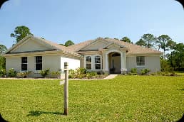 Single-story house with beige exterior and a wide front lawn